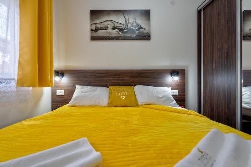 a bedroom with a large bed with yellow sheets at Durmitor 41, kompleks Titova Vila in Palisad