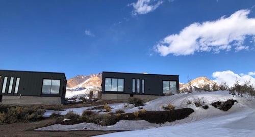 ロス・モレスにあるCabañas de Montaña Armonías Lodgeの雪山を背景にした建物