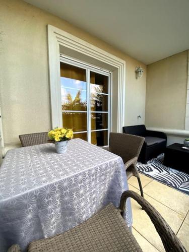 une table avec un vase de fleurs dessus dans l'établissement Urban Home - 4 pers - Netflix, à Eysines