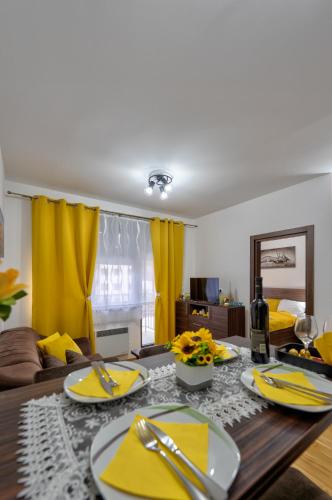 a living room with a table and yellow curtains at Durmitor 41, kompleks Titova Vila in Palisad