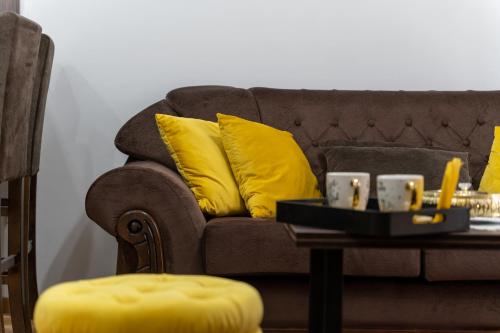 a couch with two yellow pillows and a coffee table at Durmitor 41, kompleks Titova Vila in Palisad