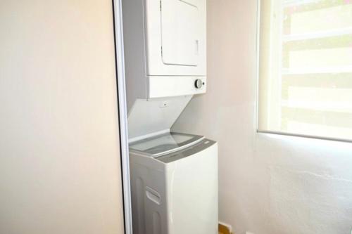 - un lave-linge et un sèche-linge dans une chambre avec fenêtre dans l'établissement Apartamento frente a la Playa Arecibo Puerto Rico, à Arecibo