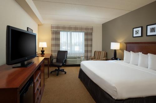 a hotel room with a bed and a flat screen tv at Country Inn & Suites by Radisson, Buffalo South I-90, NY in West Seneca