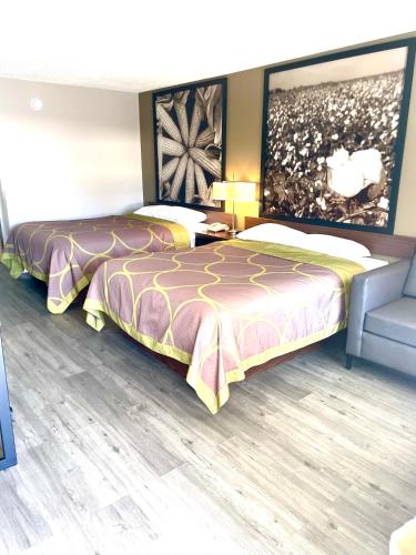 a room with two beds and a couch at Super 8 by Wyndham Bay St. Louis in Bay Saint Louis