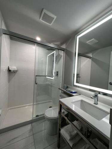 La salle de bains est pourvue d'une douche, d'un lavabo et de toilettes. dans l'établissement Travelodge by Wyndham Regina, à Regina