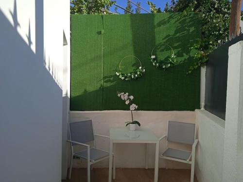 a table with two chairs and a vase with flowers on it at LR IFEMA MADRID in Madrid