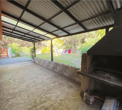 an outdoor patio with a brick fireplace in a yard at Ruca Quimei Malek in San Carlos de Bariloche