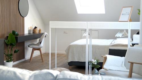 1 dormitorio con 1 cama blanca y 1 silla en F&E - gemütliche & zentrumsnahe Unterkunft en Esslingen