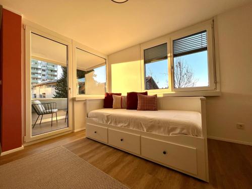 a bedroom with a bed with windows and a balcony at Apartment kleine Auszeit in Dornbirn