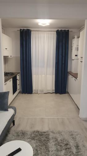 a living room with blue curtains and a couch at Hils Pallady Apartament Lyly in Bucharest