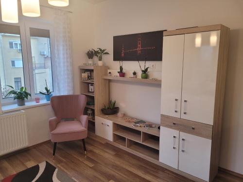 een kamer met een bureau, een stoel en een monitor bij Rosé Apartment in Pécs