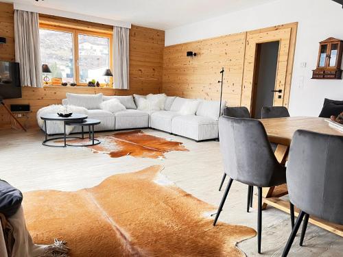 a living room with a couch and a table at Haus Diel - Premium Apartments mit Küche in Pettneu am Arlberg