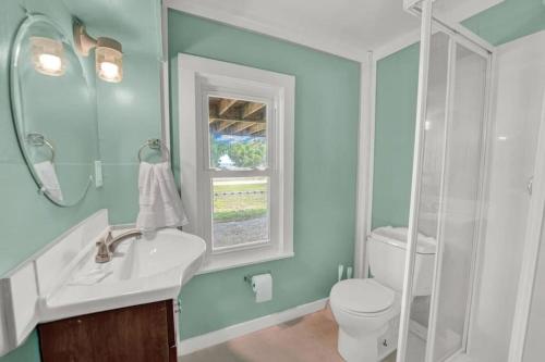 baño con lavabo y aseo y ventana en The Salty Snapper - 2 Story Home, Bay Views, Prime Location, Sleeps 8!, en St. George Island