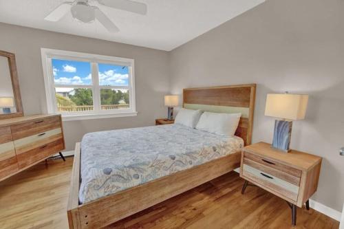 een slaapkamer met een groot bed en een raam bij The Salty Snapper - 2 Story Home, Bay Views, Prime Location, Sleeps 8! in St. George Island