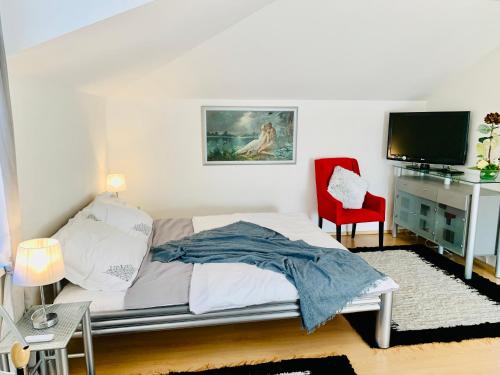 a bedroom with a bed and a red chair at Apartmán Residenz in Poprad