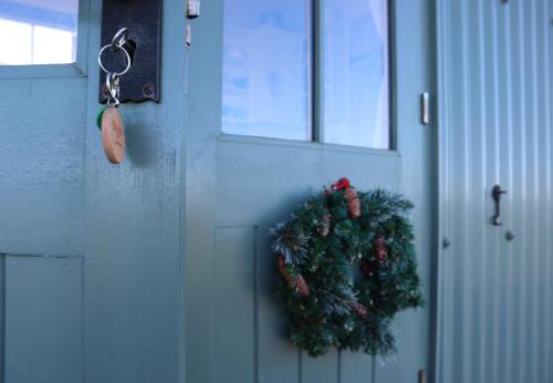 a door with a christmas wreath on it at Romney Marsh Huts by Bloom Stays in Ashford