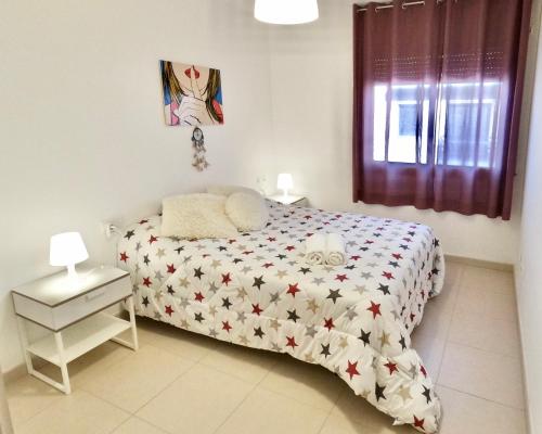 sypialnia z łóżkiem z gwiazdkami w obiekcie Duplex RIO EBRO w mieście Deltebre
