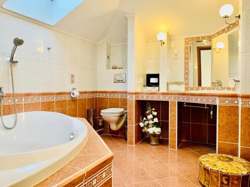 a bathroom with a tub and a toilet and a sink at Apartmán Residenz in Poprad