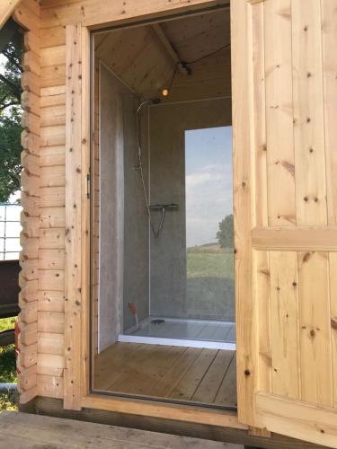 ein Badezimmer mit Badewanne in einem Holzgebäude in der Unterkunft Gwynfyd Bell Tent in Abergavenny