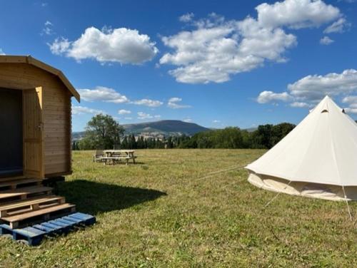 ein Zelt und ein Tipi auf einem Feld in der Unterkunft Gwynfyd Bell Tent in Abergavenny