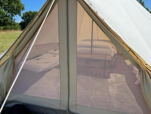 a window of a tent with a bed in it at Gwynfyd Bell Tent in Abergavenny