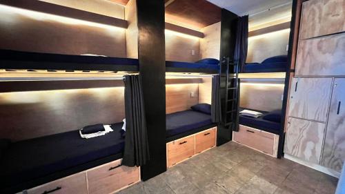 um quarto com 3 beliches com assentos azuis em Jet's Gay Youth Hostel em Puerto Vallarta