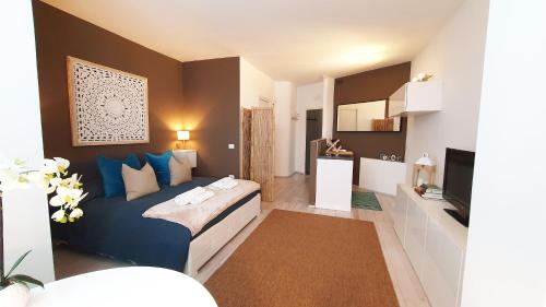 - une chambre avec un lit bleu et une télévision dans l'établissement Apartment Giotto Eremitani, à Padoue