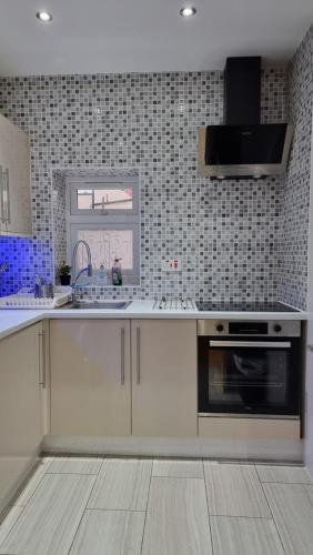 een keuken met witte kasten en een fornuis met oven bij 2 ROOMS ANNEX (TV+WiFi) in Chigwell