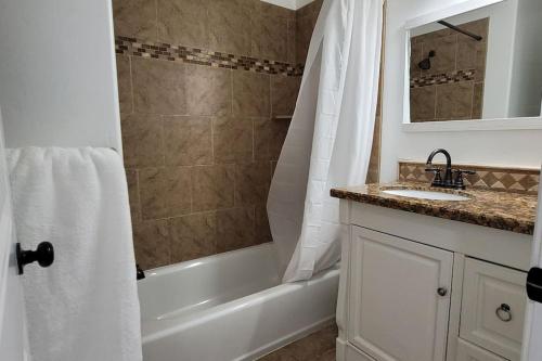 y baño con bañera, lavamanos y ducha. en 5 bedroom house to share with your family and friends en Provo