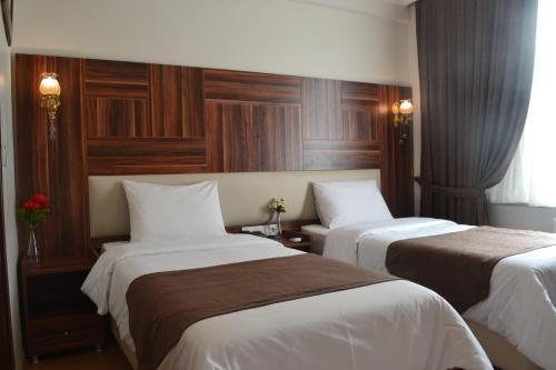 a hotel room with two beds with white sheets at New Fatih Hotel in Istanbul