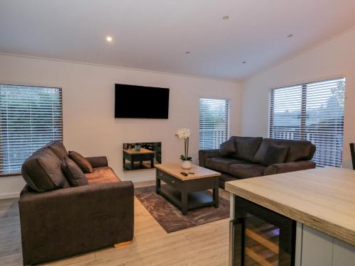 a living room with two couches and a fireplace at 25 Thirlmere in Windermere