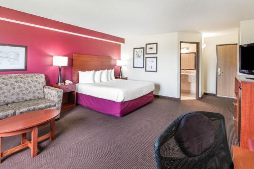 Habitación de hotel con cama, sofá y silla en SureStay Plus Hotel by Best Western Litchfield, en Litchfield