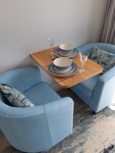 a living room with a table and two chairs at Seascape Hideaway Pohara in Pohara