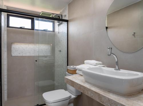 a bathroom with a sink and a toilet and a mirror at Charme na Barra da Tijuca - Bela Vista - AM203 Z10 in Rio de Janeiro