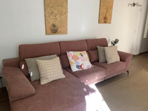a brown couch with pillows in a living room at Cabo de Gata Oasis Retamar in El Toyo
