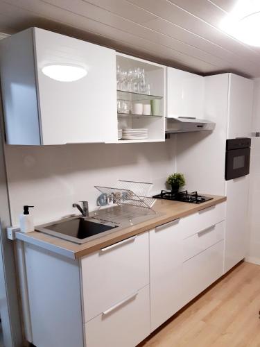 une cuisine avec des armoires blanches et un évier dans l'établissement Maison de ville Sélestat centre, à Sélestat