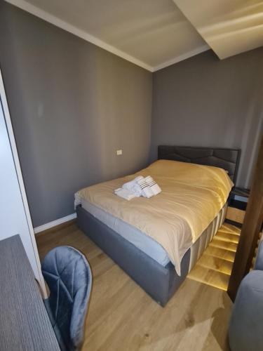 a small bedroom with a bed and a chair at Sunny Apartment - Blloku Tirana, near Lake in Tirana