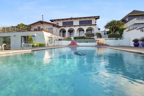a large swimming pool in front of a house at Magnificent Beachfront Mansion - Pool - Fireplace in Auckland