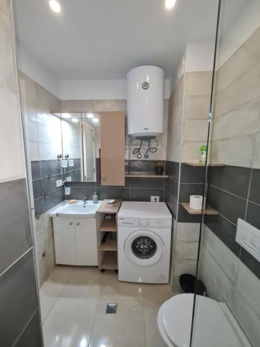 a bathroom with a washing machine and a sink at Sunny Apartment - Blloku Tirana, near Lake in Tirana