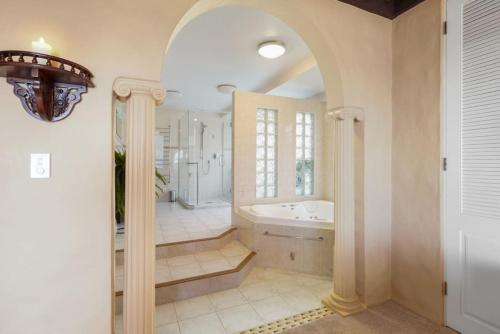 a large bathroom with a tub and a sink at Magnificent Beachfront Mansion - Pool - Fireplace in Auckland