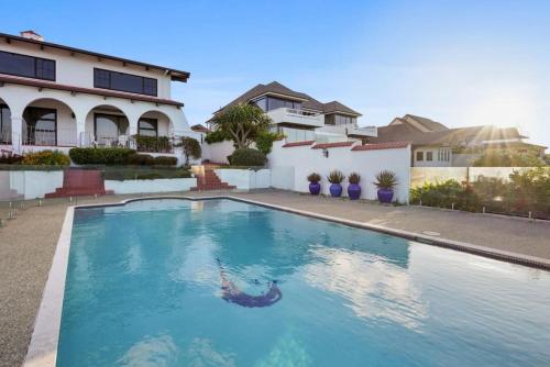 a swimming pool in front of a house at Magnificent Beachfront Mansion - Pool - Fireplace in Auckland