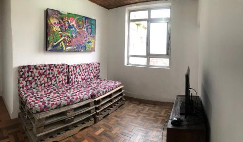 un canapé dans une pièce avec un tableau mural dans l'établissement Hostel Selaron, à Rio de Janeiro