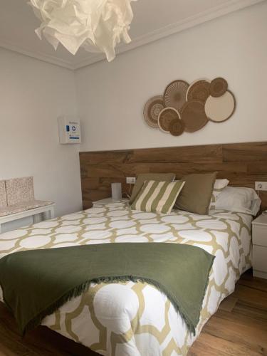 a bedroom with a bed with hats on the wall at Rincón Santa Eulalia. Parking y Desayuno incluido. in Murcia