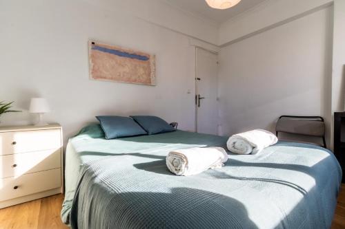 een slaapkamer met 2 bedden en handdoeken bij AL Cacém in Paiõis