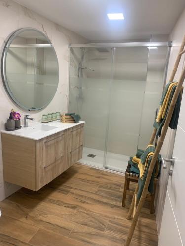 a bathroom with a sink and a mirror and a shower at Rincón Santa Eulalia. Parking y Desayuno incluido. in Murcia