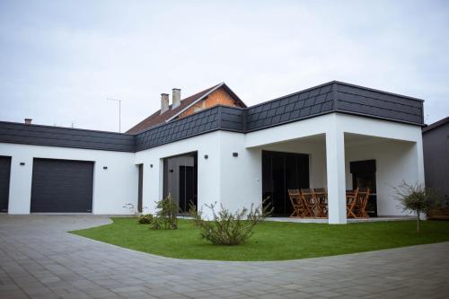 une maison blanche avec un toit noir dans l'établissement Villa Spa Heaven, à Novska