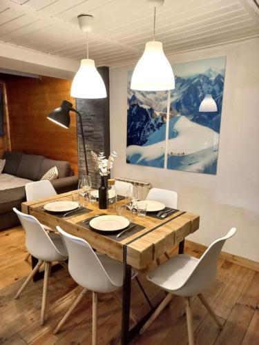 Bel appartement familial et cosy في سان جيرفيه ليه بان: غرفة طعام مع طاولة خشبية وكراسي بيضاء