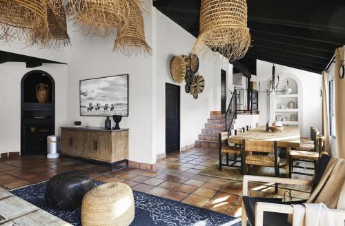 a living room with a table and a dining room at Television Host and Designer Bobby Berk Invites You To His Desert Oasis in Palm Desert