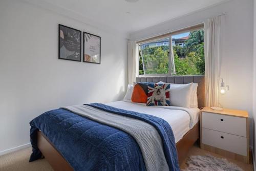 un dormitorio con una cama con un perro sentado en ella en Mission Bay Secret Garden Hideaway - Netflix WIFI en Auckland
