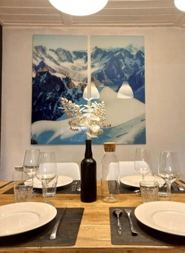 a wooden table with a bottle of wine and glasses at Bel appartement familial et cosy in Saint-Gervais-les-Bains